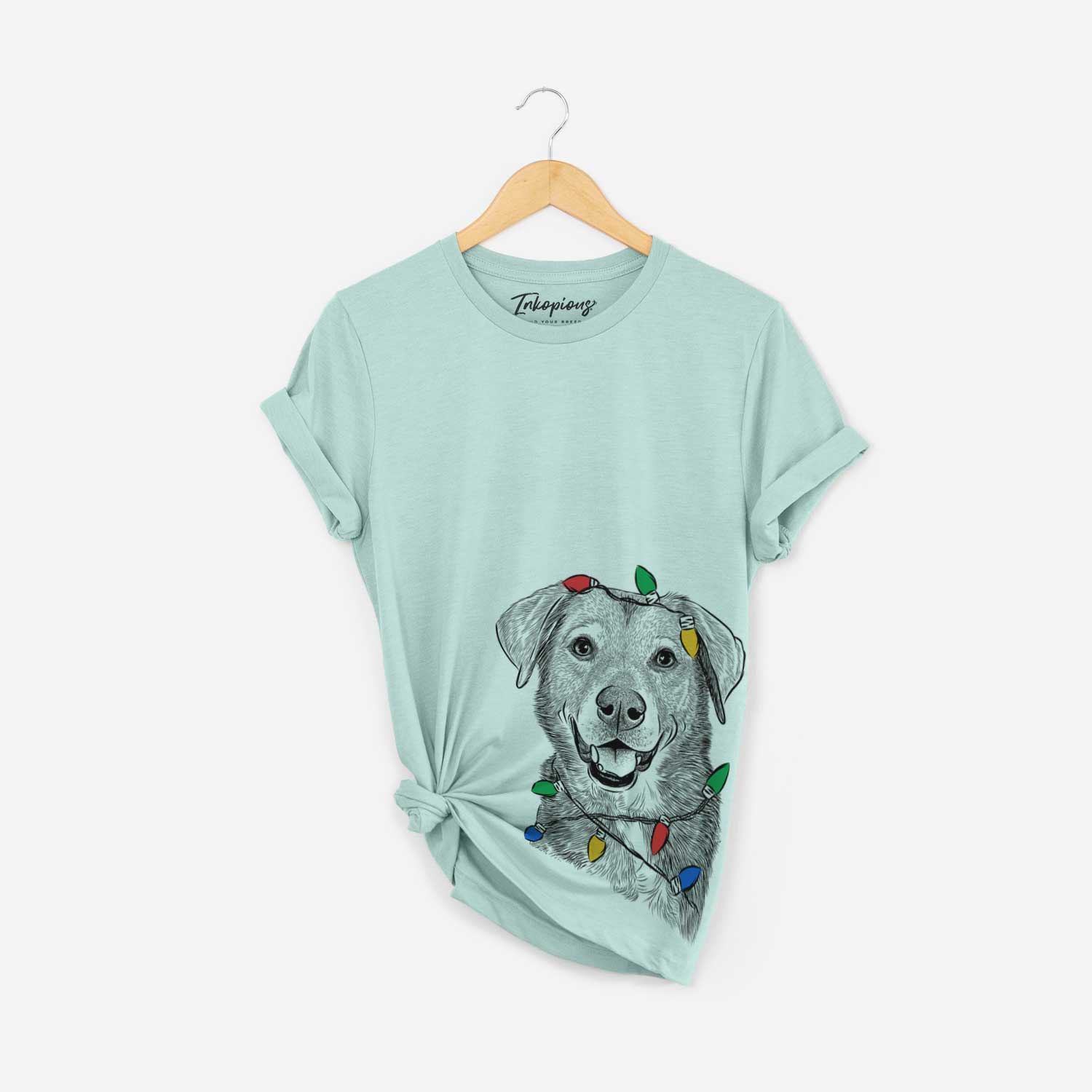 Hand-drawn sketch of Oliver the Mixed Breed wrapped in Christmas lights on a Heather Sage Unisex crewneck