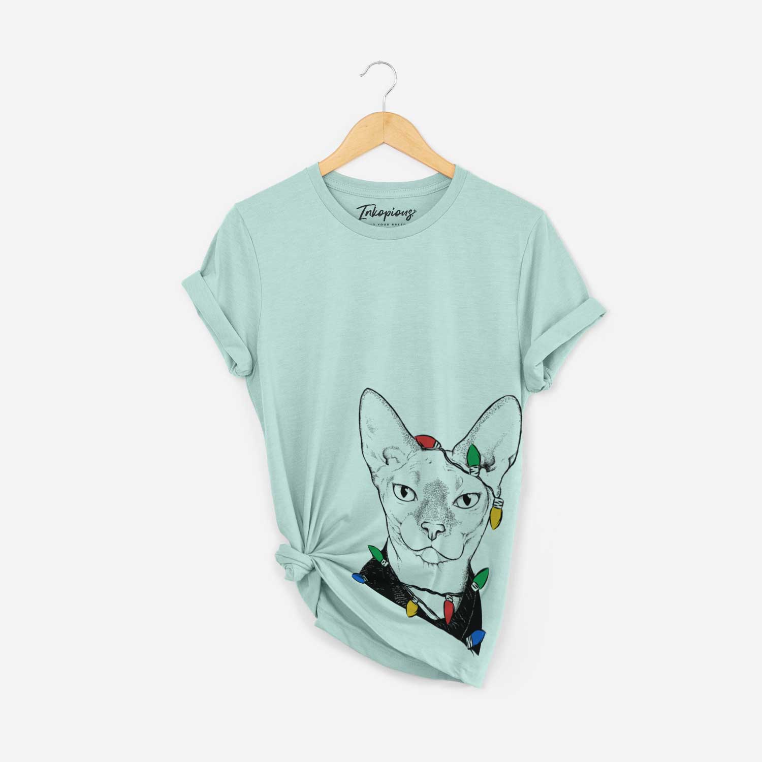 Hand-drawn sketch of Oliver Watson the Sphynx Cat wrapped in Christmas lights on a Heather Sage Unisex crewneck