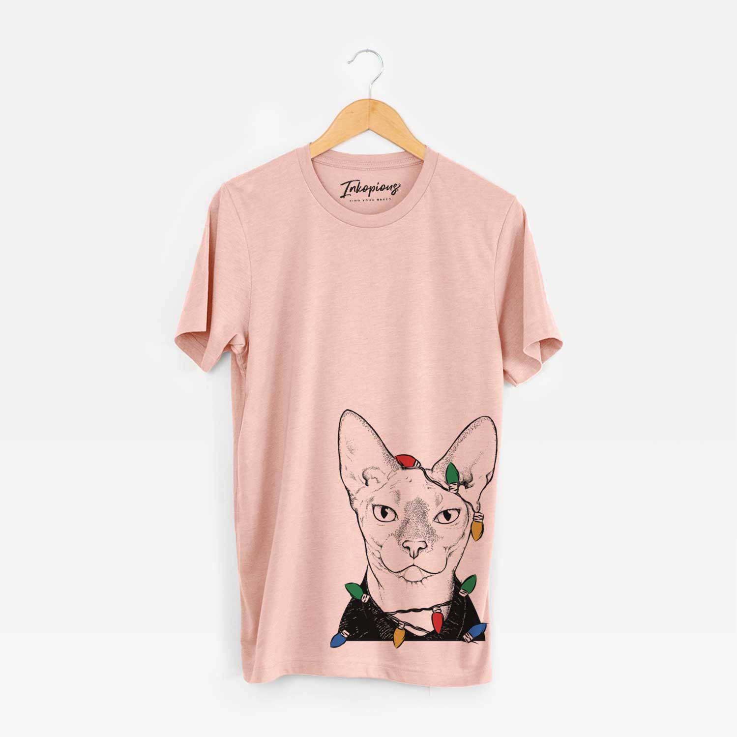 Hand-drawn sketch of Oliver Watson the Sphynx Cat wrapped in Christmas lights on a Peach Unisex crewneck