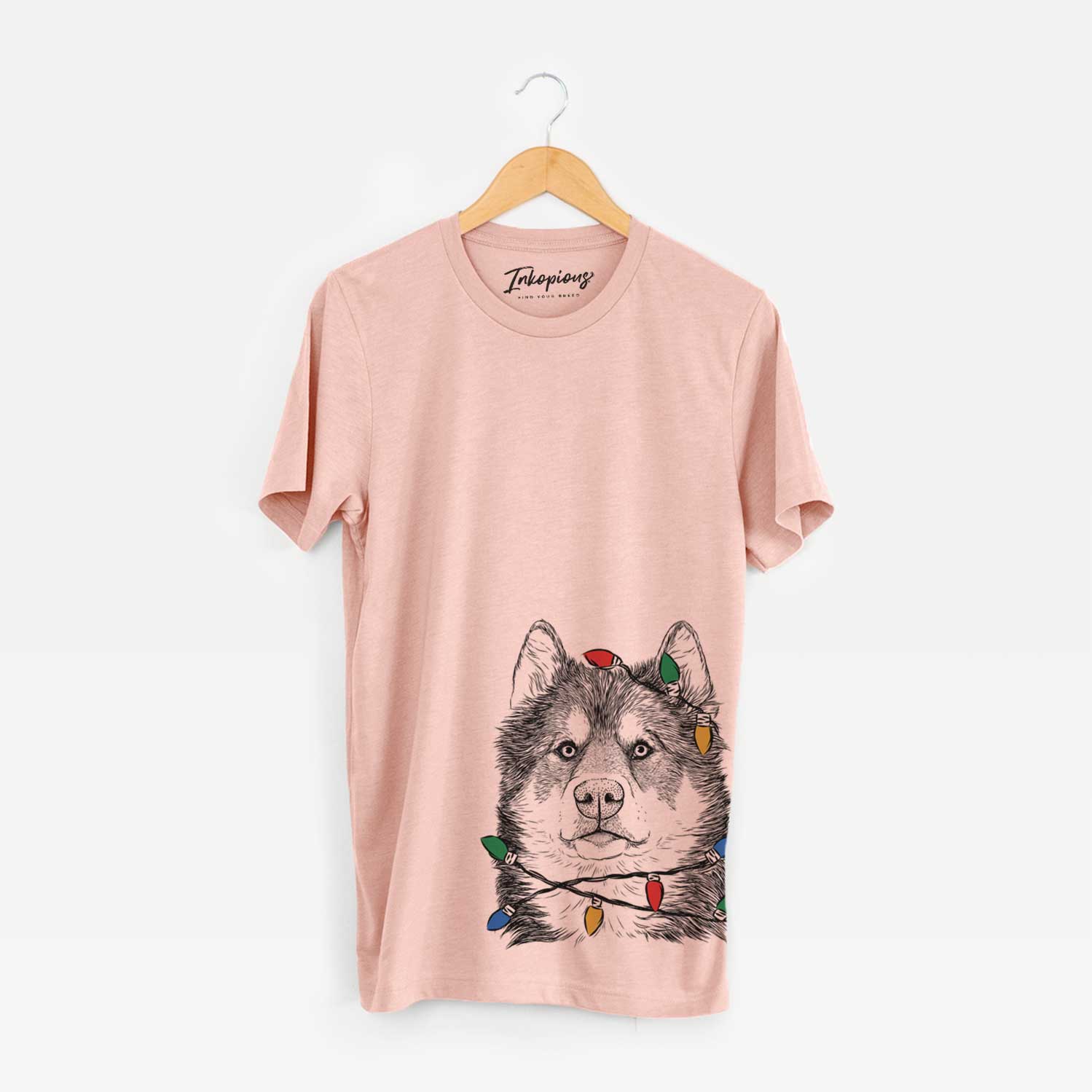 Hand-drawn sketch of Oskar the Canadian Eskimo Dog wrapped in Christmas lights on a Peach Unisex crewneck