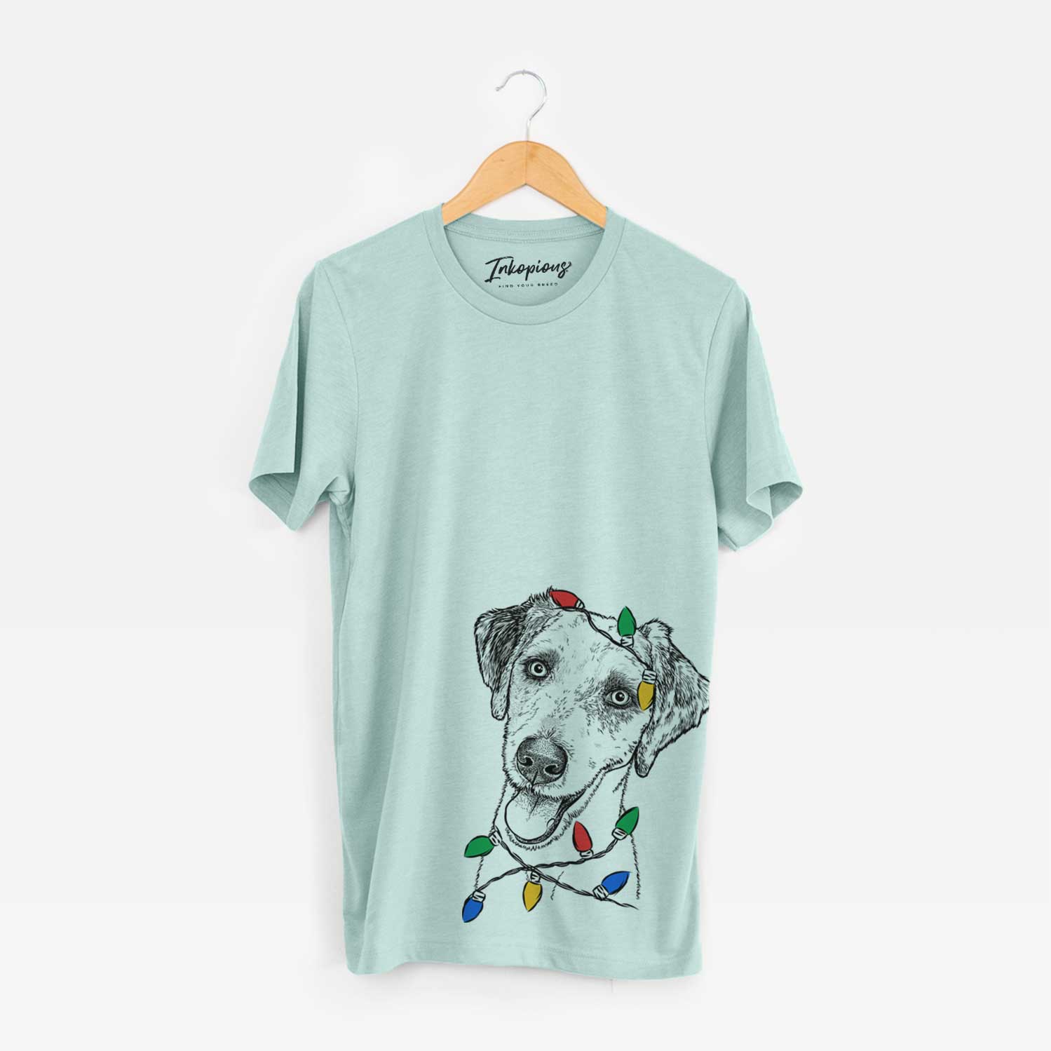 Hand-drawn sketch of Palm Palm the Aussiedoodle wrapped in Christmas lights on a Heather Sage Unisex crewneck