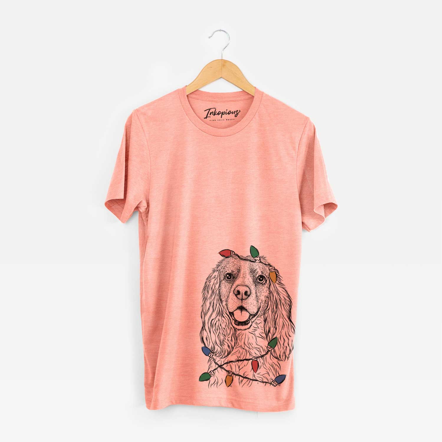 Hand-drawn sketch of Perry the Cockalier wrapped in Christmas lights on a Sunset Unisex crewneck