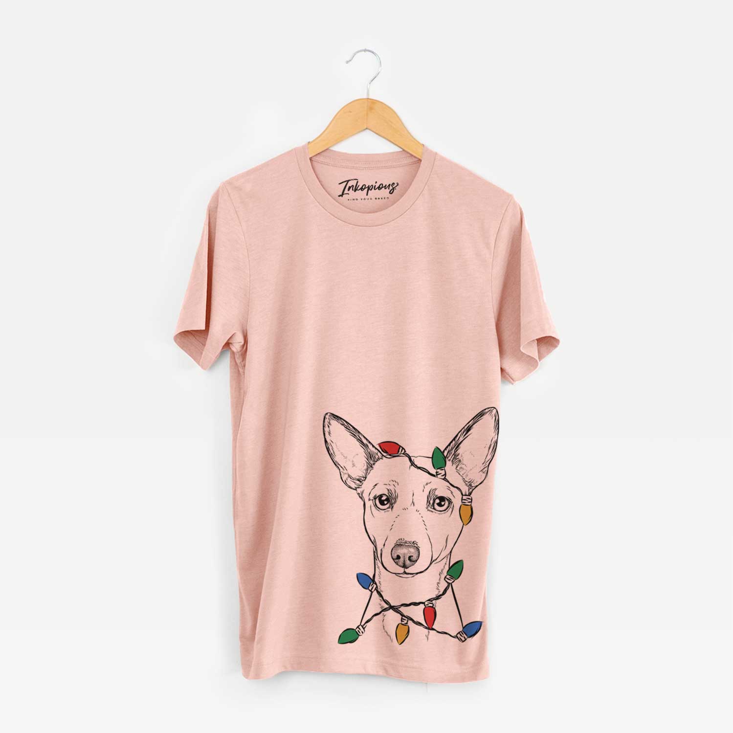Hand-drawn sketch of Perry the Portuguese Podengo wrapped in Christmas lights on a Peach Unisex crewneck