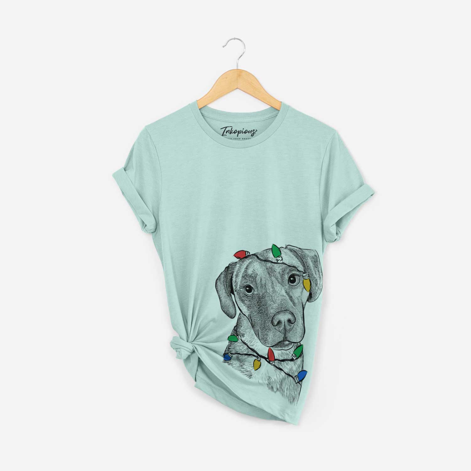 Hand-drawn sketch of Peyton Manning the Beagle Bulldog Mix wrapped in Christmas lights on a Heather Sage Unisex crewneck