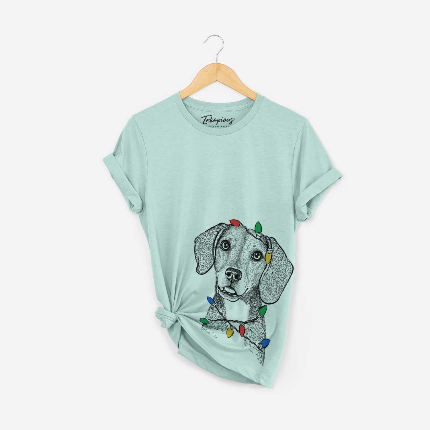 Hand-drawn sketch of Piggy the Beagle Mix wrapped in Christmas lights on a Heather Sage Unisex crewneck