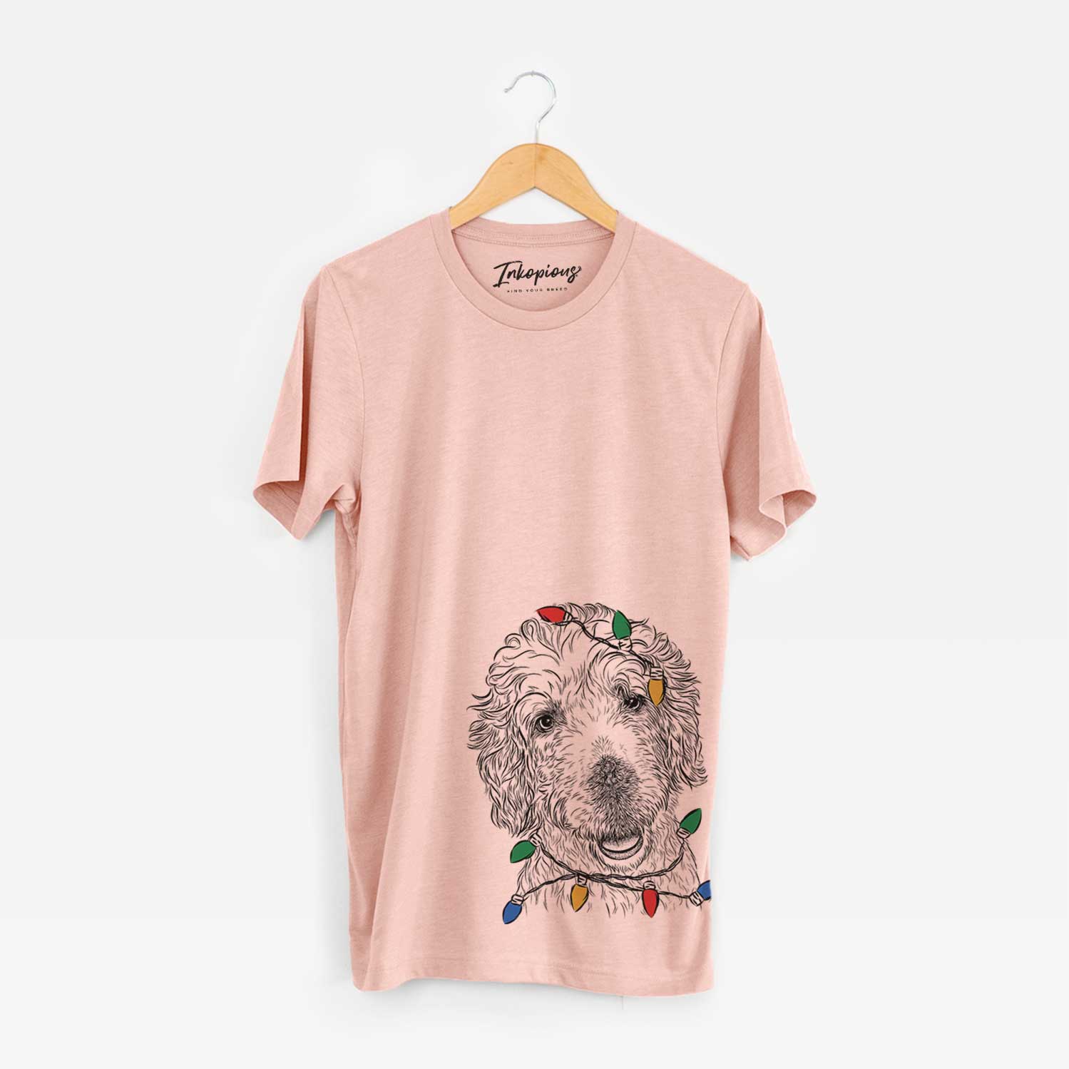 Hand-drawn sketch of Preston the Labradoodle wrapped in Christmas lights on a Peach Unisex crewneck