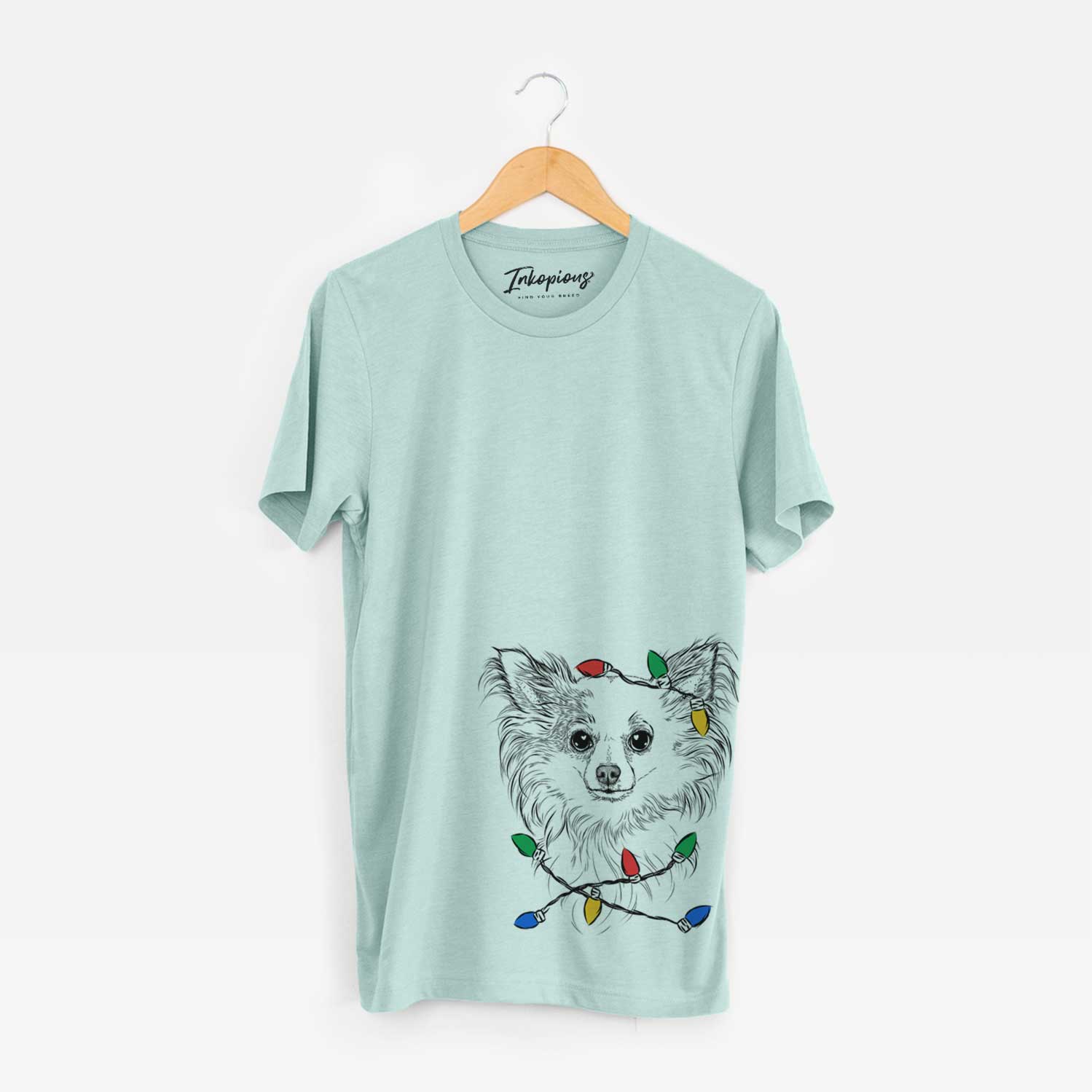 Hand-drawn sketch of Princess Ava the Long Haired Chihuahua wrapped in Christmas lights on a Heather Sage Unisex crewneck