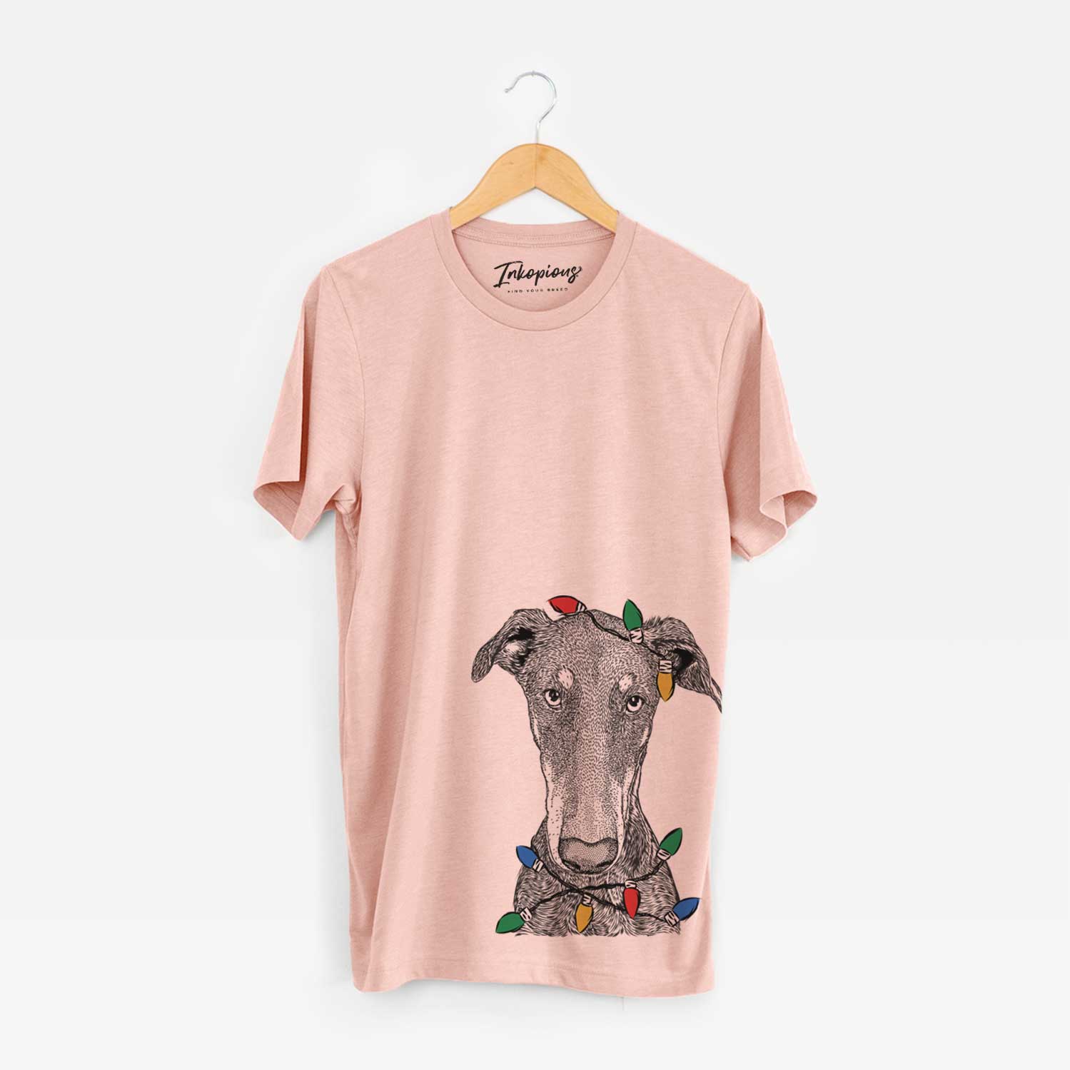 Hand-drawn sketch of Princess Fiona the Doberman Pinscher wrapped in Christmas lights on a Peach Unisex crewneck