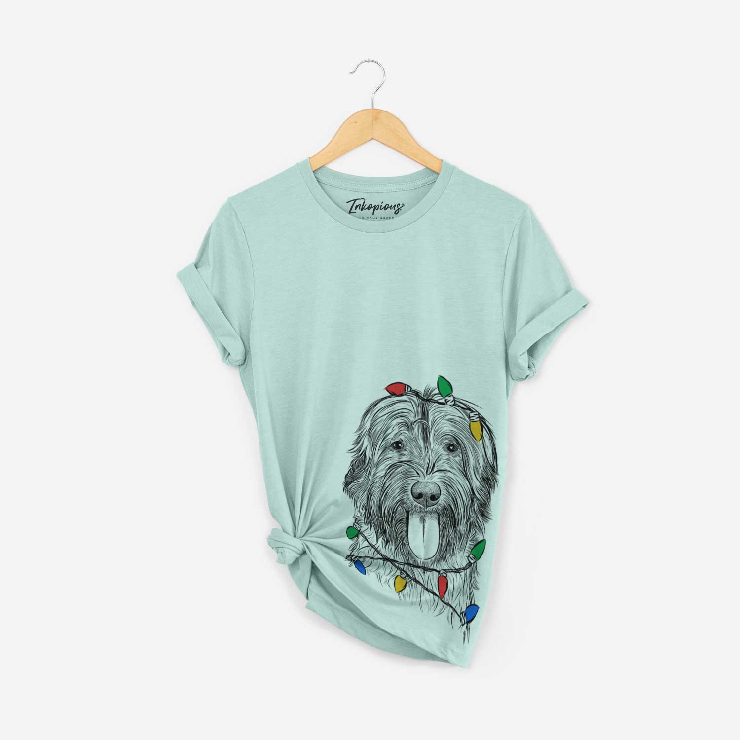 Hand-drawn sketch of Puig the Catalan Sheepdog wrapped in Christmas lights on a Heather Sage Unisex crewneck