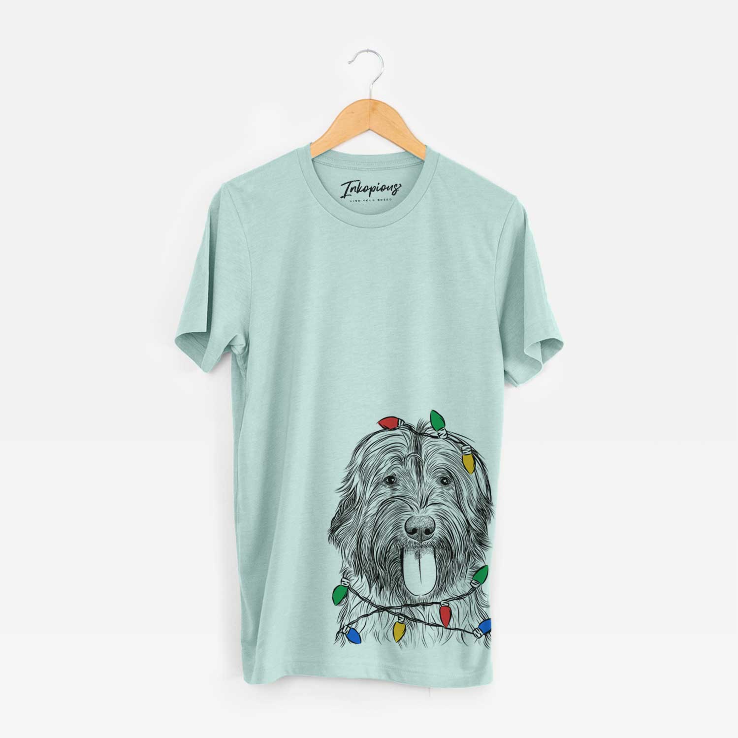 Hand-drawn sketch of Puig the Catalan Sheepdog wrapped in Christmas lights on a Heather Sage Unisex crewneck