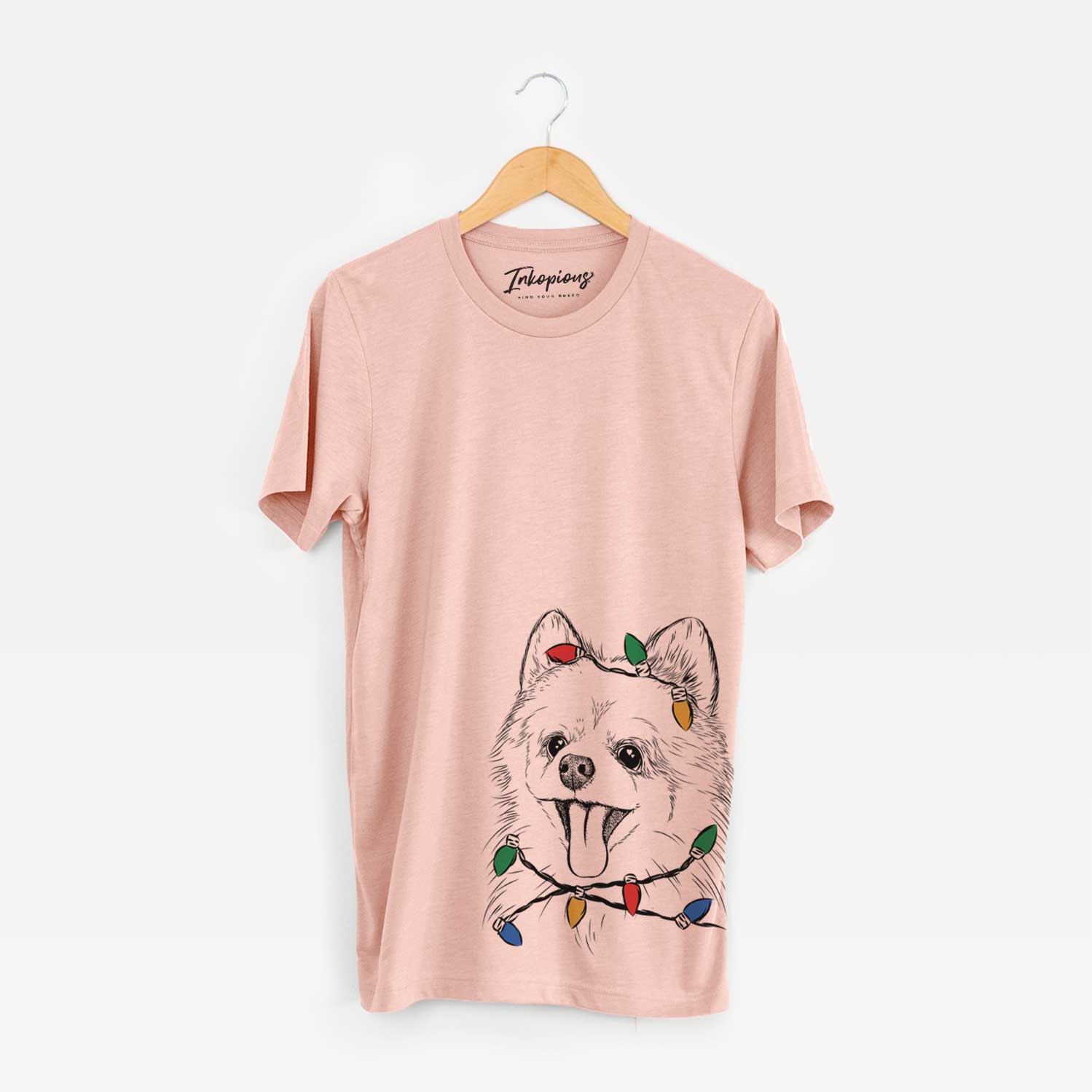 Hand-drawn sketch of Quinn the Pomeranian wrapped in Christmas lights on a Peach Unisex crewneck