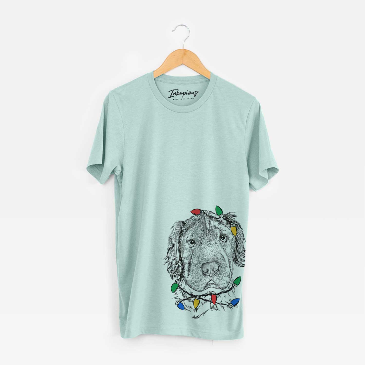 Hand-drawn sketch of Rex the Mini Hippo wrapped in Christmas lights on a Heather Sage Unisex crewneck