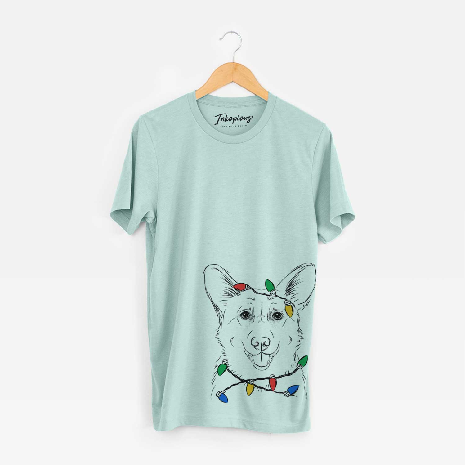 Hand-drawn sketch of Ricco the Corgi wrapped in Christmas lights on a Heather Sage Unisex crewneck