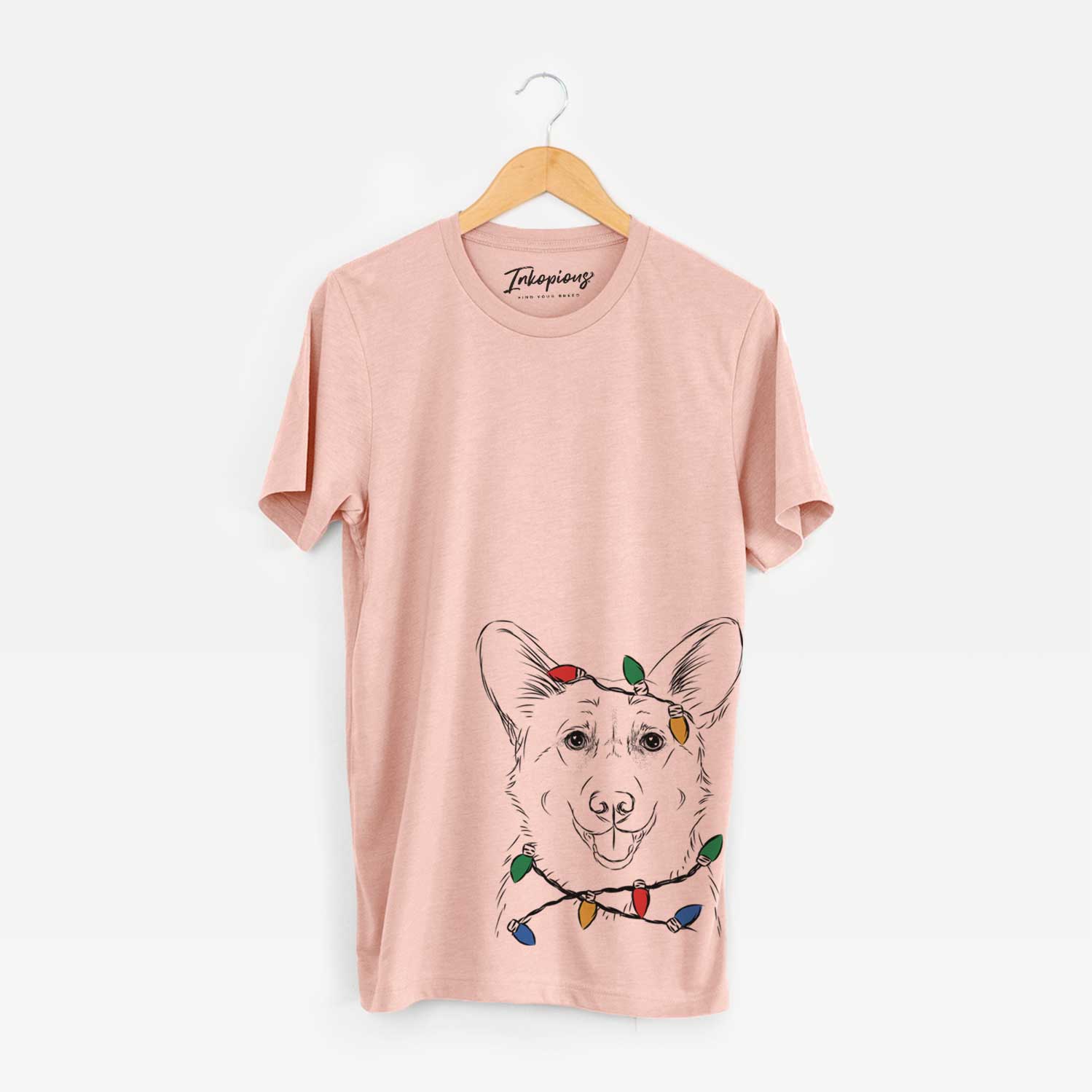 Hand-drawn sketch of Ricco the Corgi wrapped in Christmas lights on a Peach Unisex crewneck