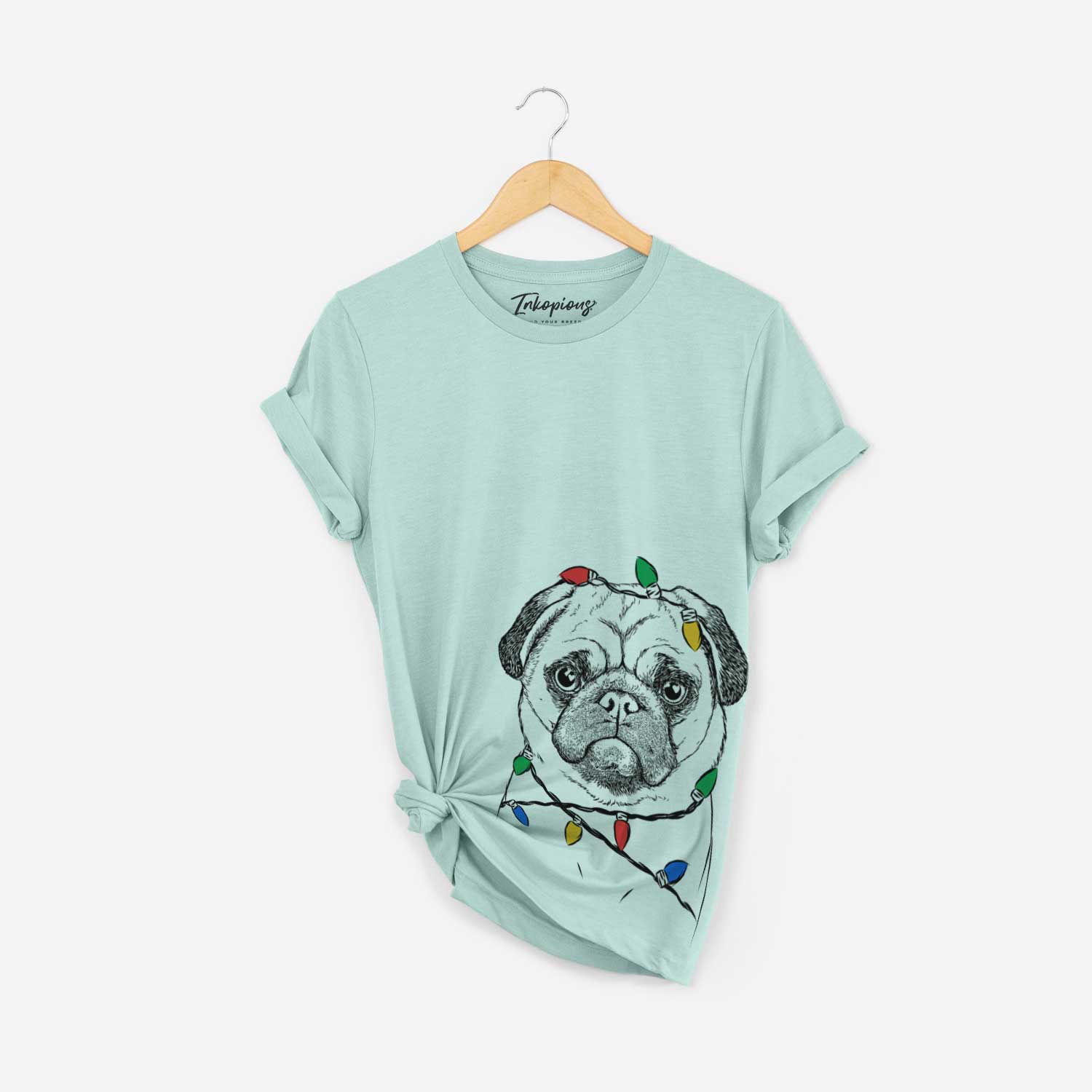 Hand-drawn sketch of Ruby the Pug wrapped in Christmas lights on a Heather Sage Unisex crewneck