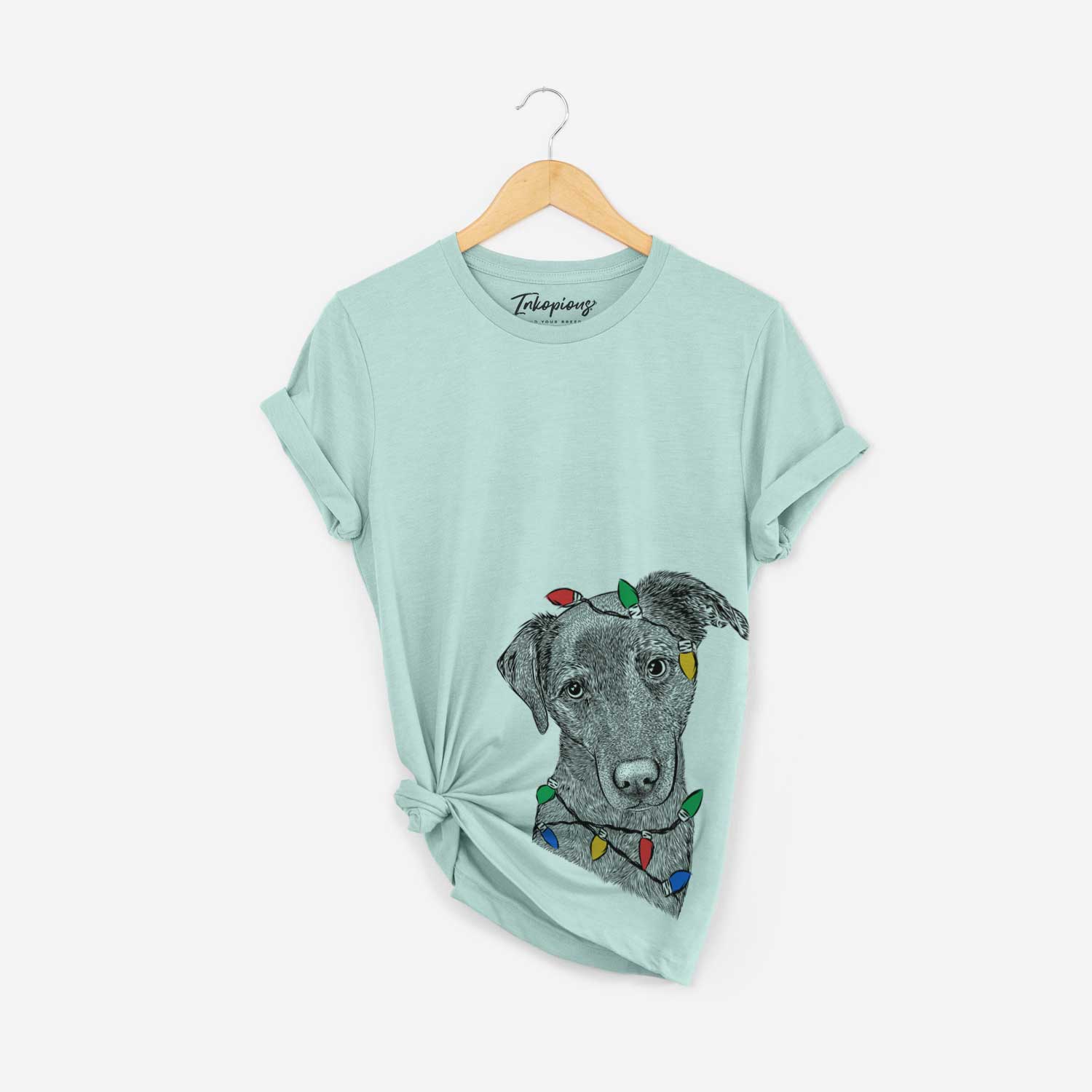 Hand-drawn sketch of Sadie the Whipador wrapped in Christmas lights on a Heather Sage Unisex crewneck
