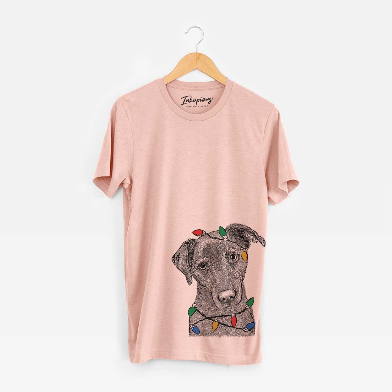 Hand-drawn sketch of Sadie the Whipador wrapped in Christmas lights on a Peach Unisex crewneck