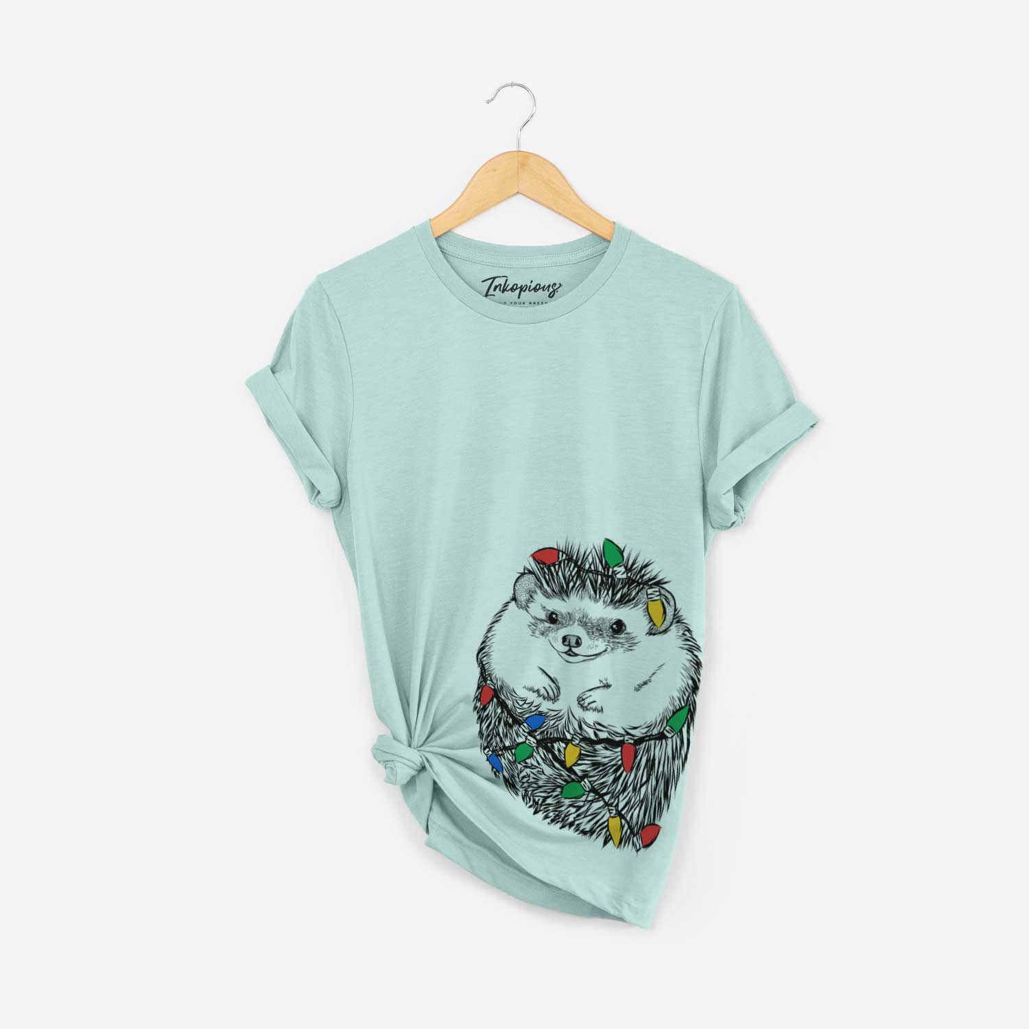 Hand-drawn sketch of Sid the Hedgehog wrapped in Christmas lights on a Heather Sage Unisex crewneck