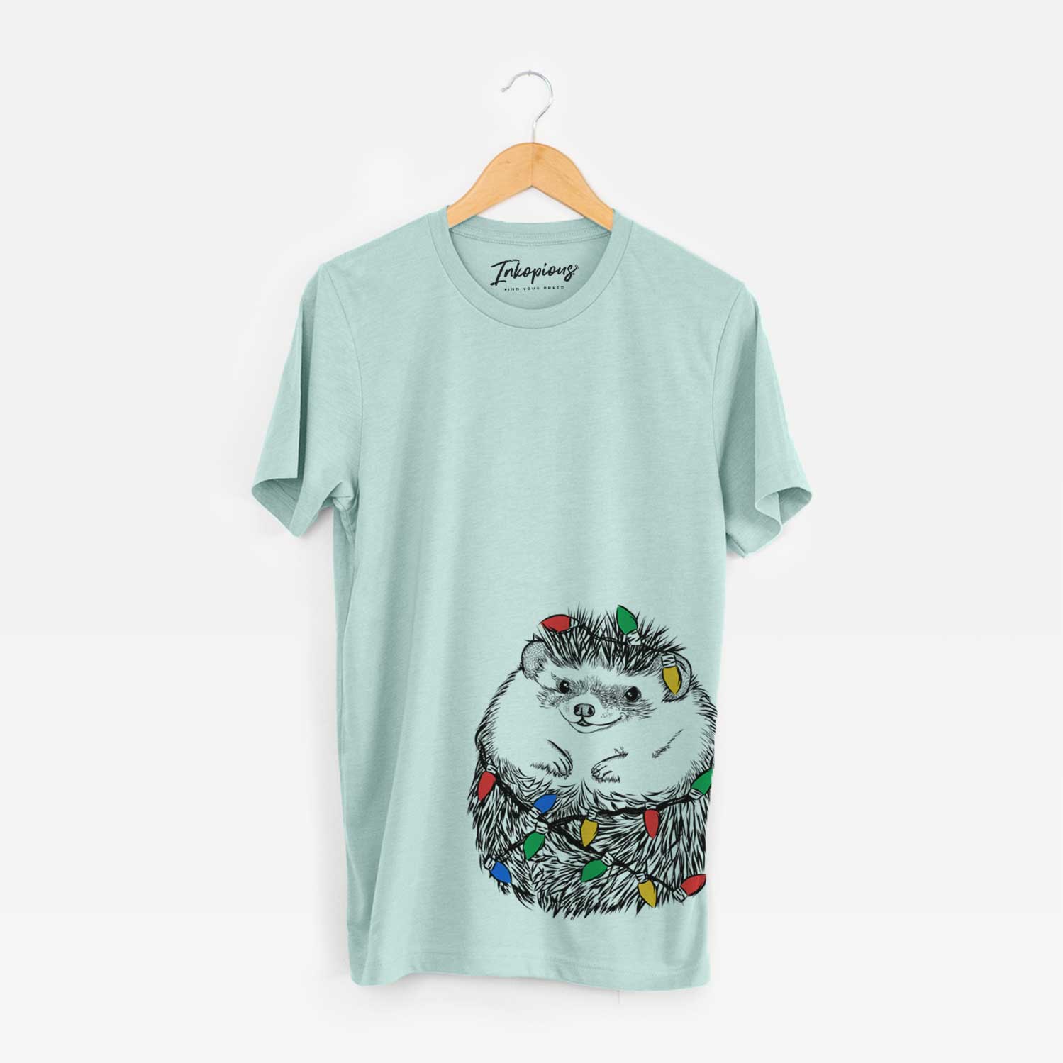 Hand-drawn sketch of Sid the Hedgehog wrapped in Christmas lights on a Heather Sage Unisex crewneck