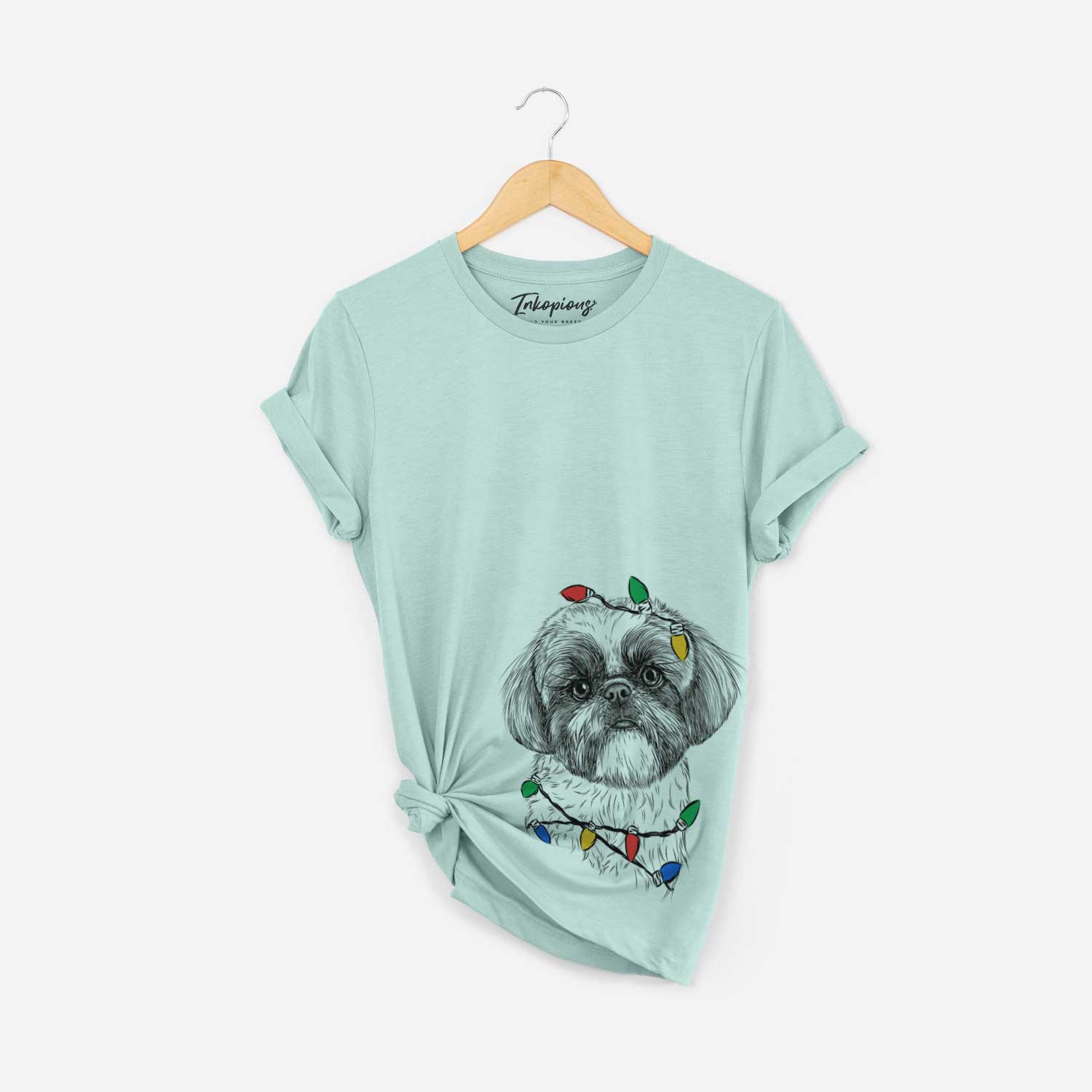 Hand-drawn sketch of Simon the Shih Tzu wrapped in Christmas lights on a Heather Sage Unisex crewneck