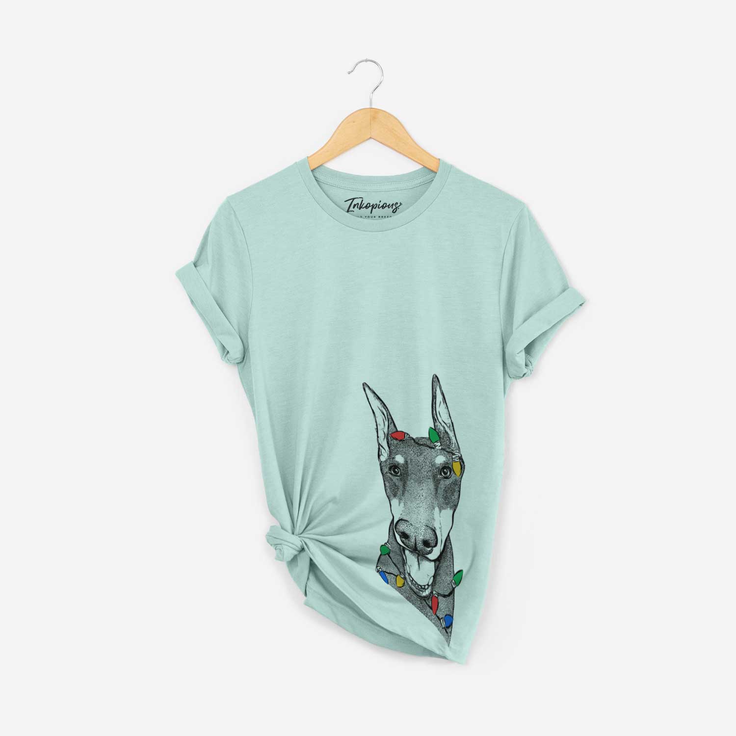 Hand-drawn sketch of Sir Duke the Doberman Pinscher wrapped in Christmas lights on a Heather Sage Unisex crewneck