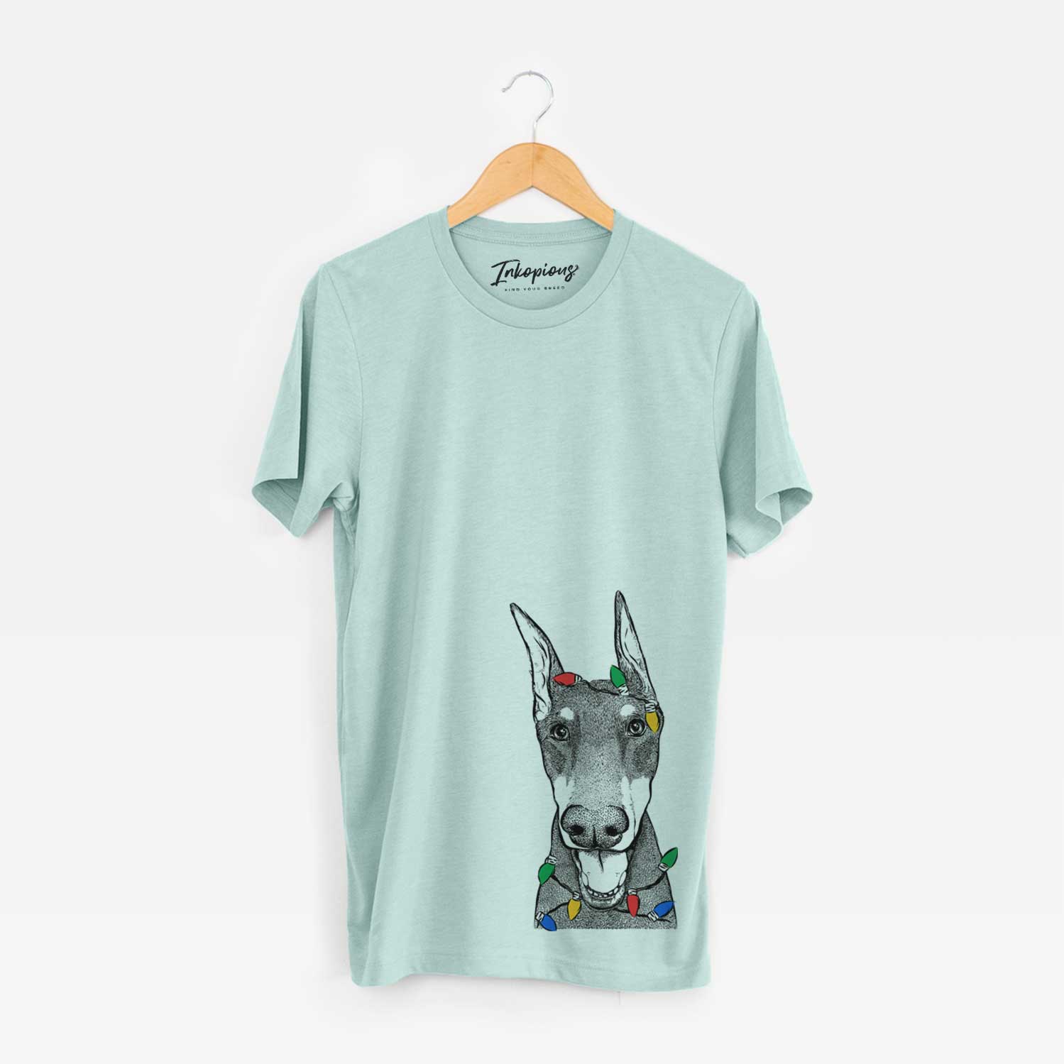 Hand-drawn sketch of Sir Duke the Doberman Pinscher wrapped in Christmas lights on a Heather Sage Unisex crewneck