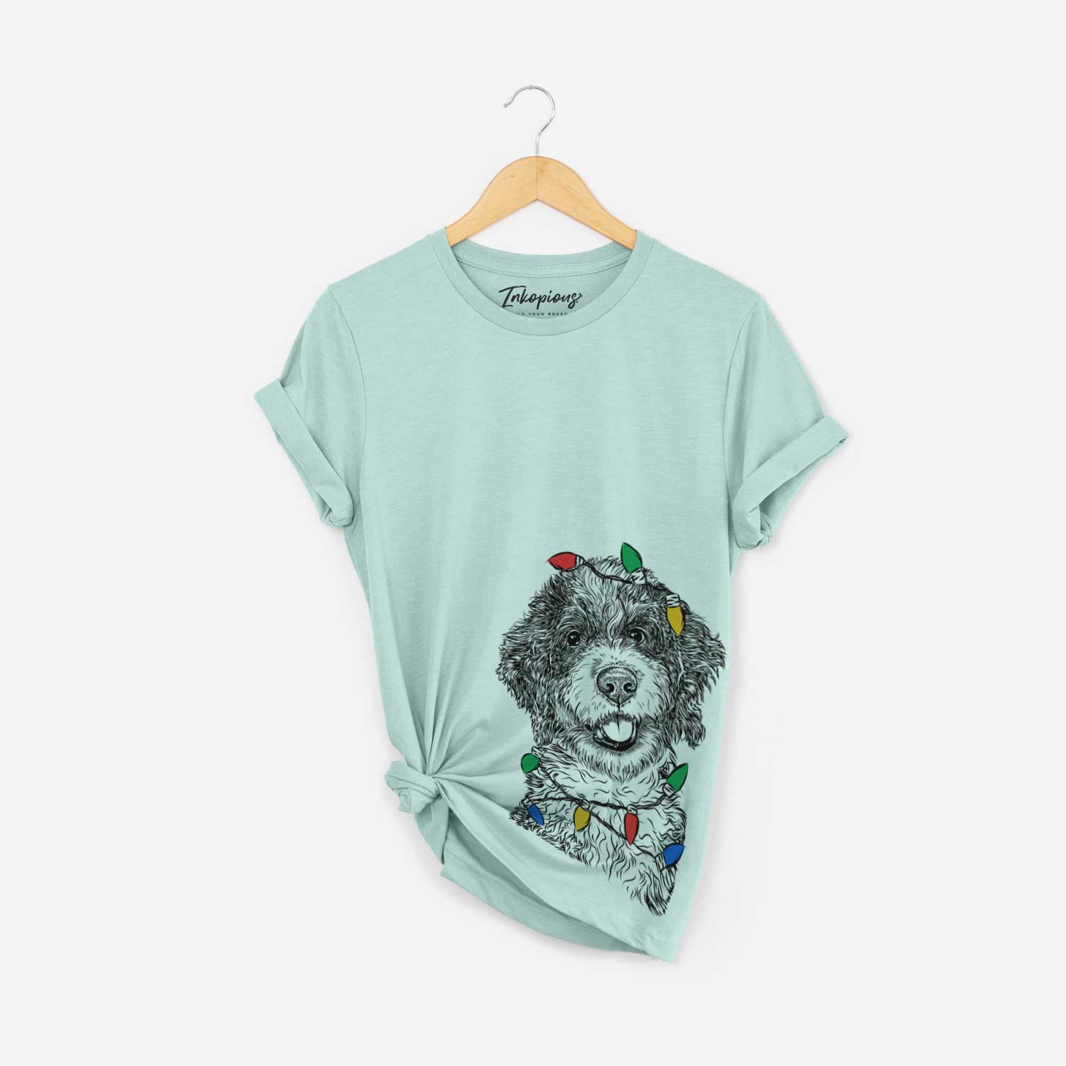 Hand-drawn sketch of Smoky the Bernedoodle Puppy wrapped in Christmas lights on a Heather Sage Unisex crewneck