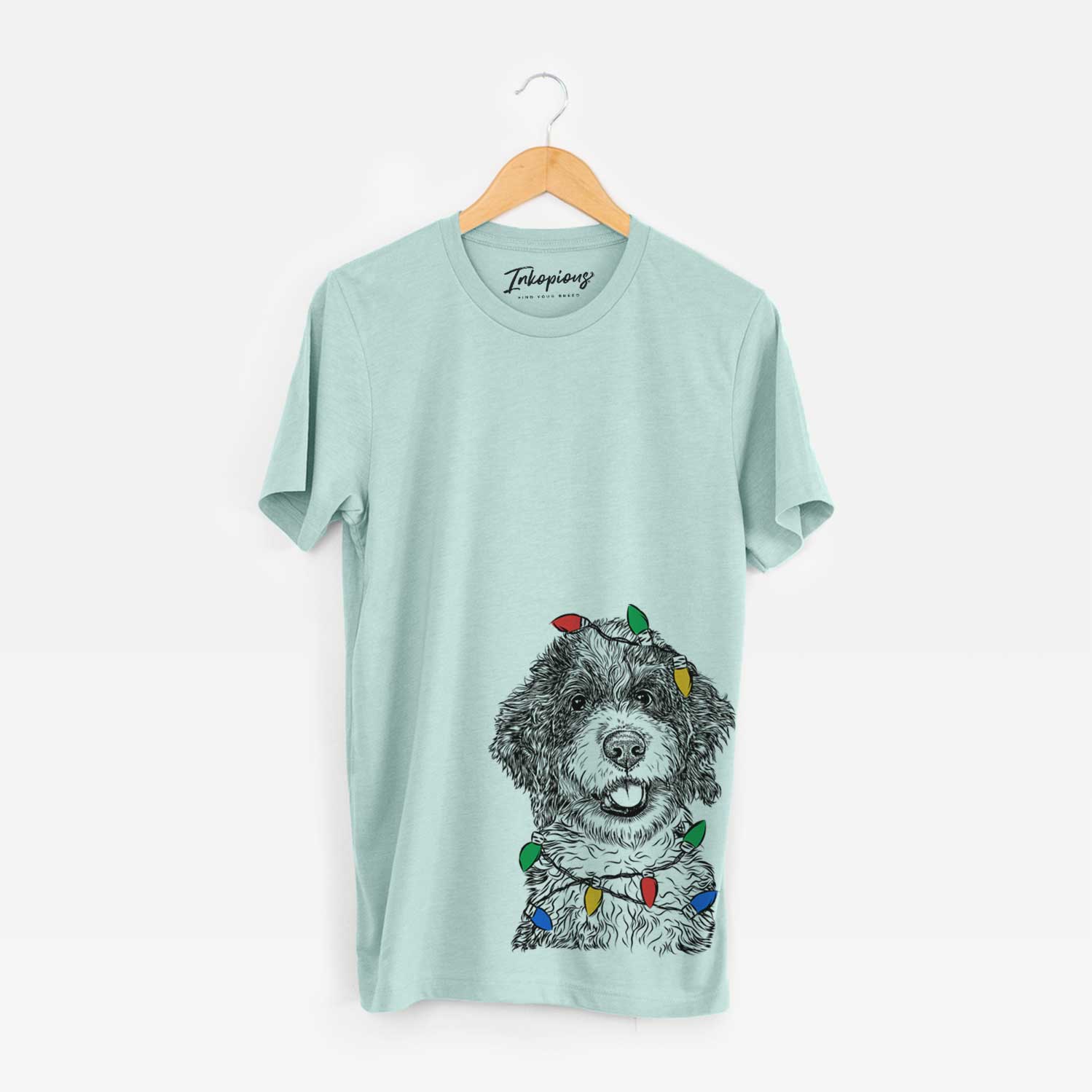Hand-drawn sketch of Smoky the Bernedoodle Puppy wrapped in Christmas lights on a Heather Sage Unisex crewneck