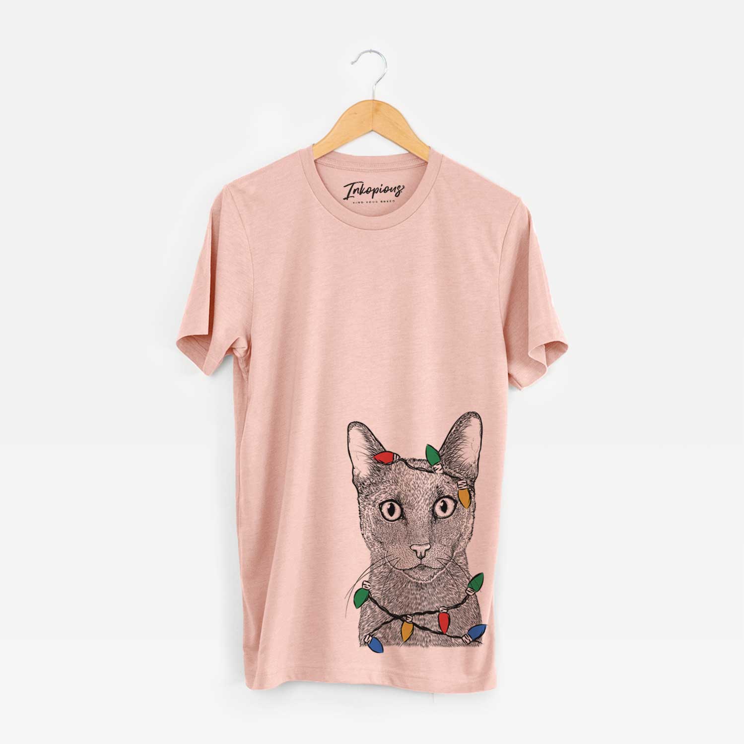 Hand-drawn sketch of Stanley the Russian Blue Cat wrapped in Christmas lights on a Peach Unisex crewneck