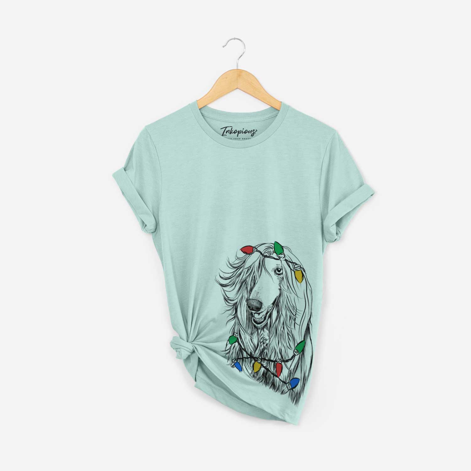 Hand-drawn sketch of Sterling the Afghan Hound wrapped in Christmas lights on a Heather Sage Unisex crewneck