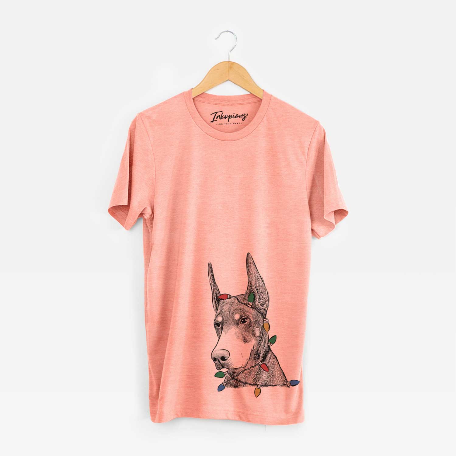 Hand-drawn sketch of Sunny the Doberman Pinscher wrapped in Christmas lights on a Sunset Unisex crewneck