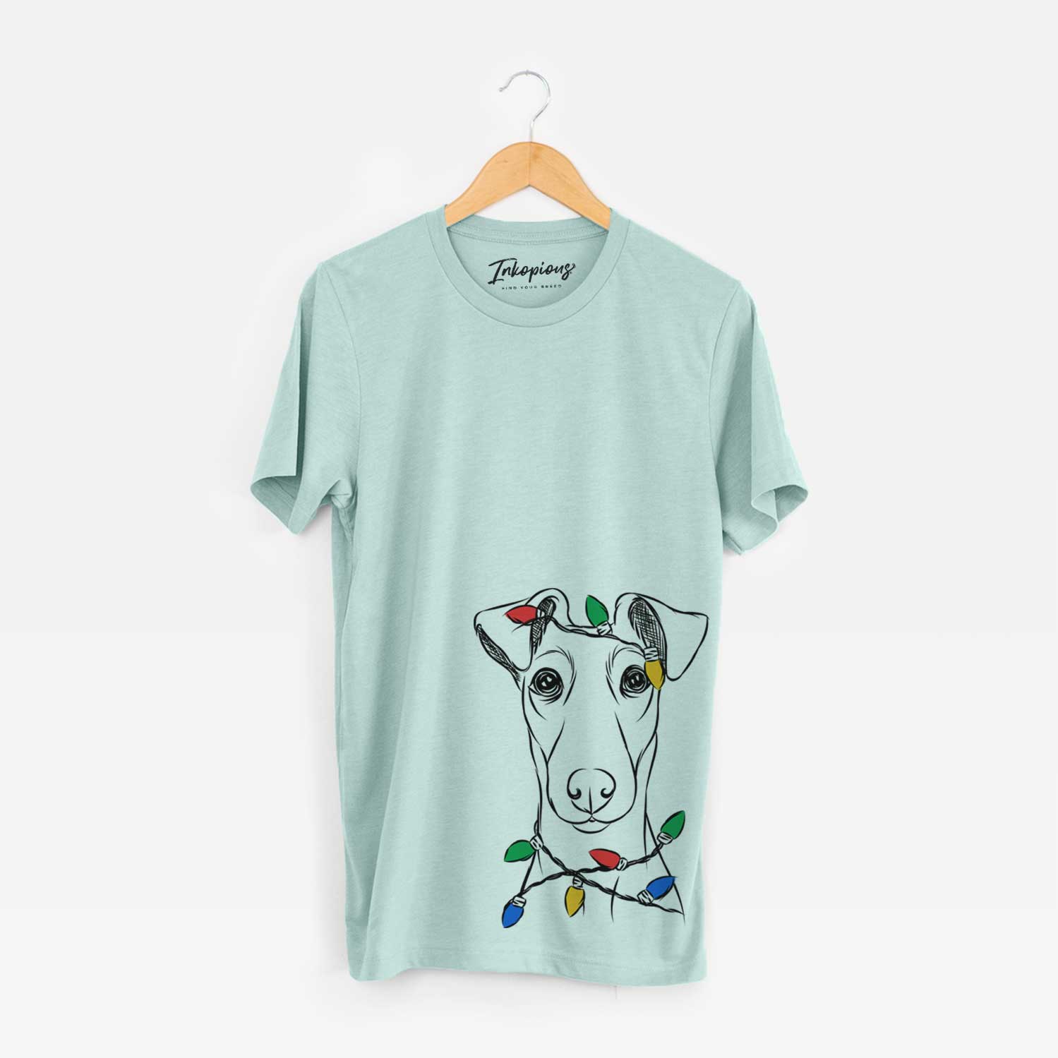 Hand-drawn sketch of Tanner the Fox Terrier wrapped in Christmas lights on a Heather Sage Unisex crewneck