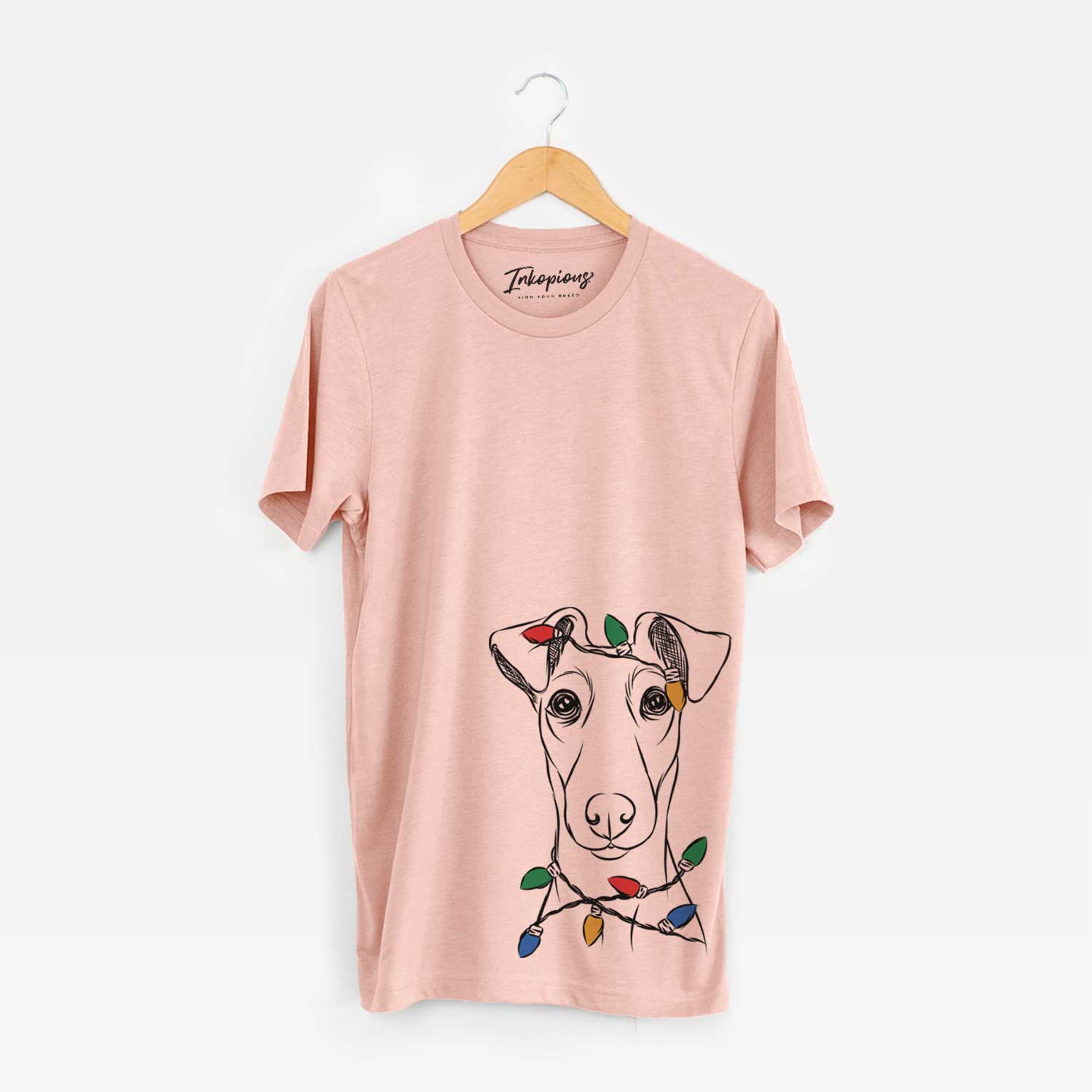 Hand-drawn sketch of Tanner the Fox Terrier wrapped in Christmas lights on a Peach Unisex crewneck