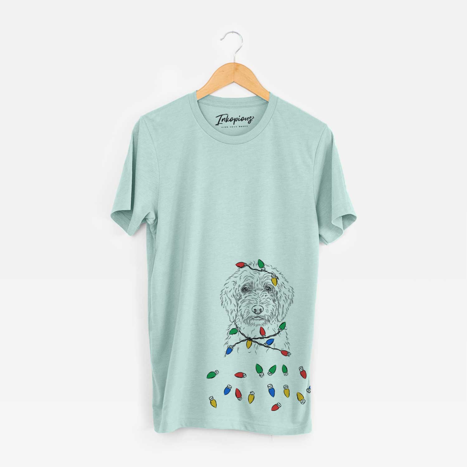 Hand-drawn sketch of Teddy the Labradoodle wrapped in Christmas lights on a Heather Sage Unisex crewneck