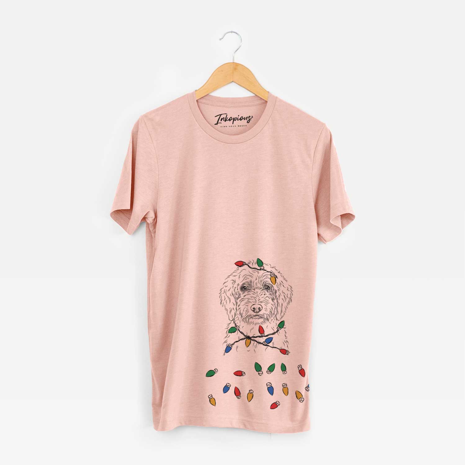 Hand-drawn sketch of Teddy the Labradoodle wrapped in Christmas lights on a Peach Unisex crewneck