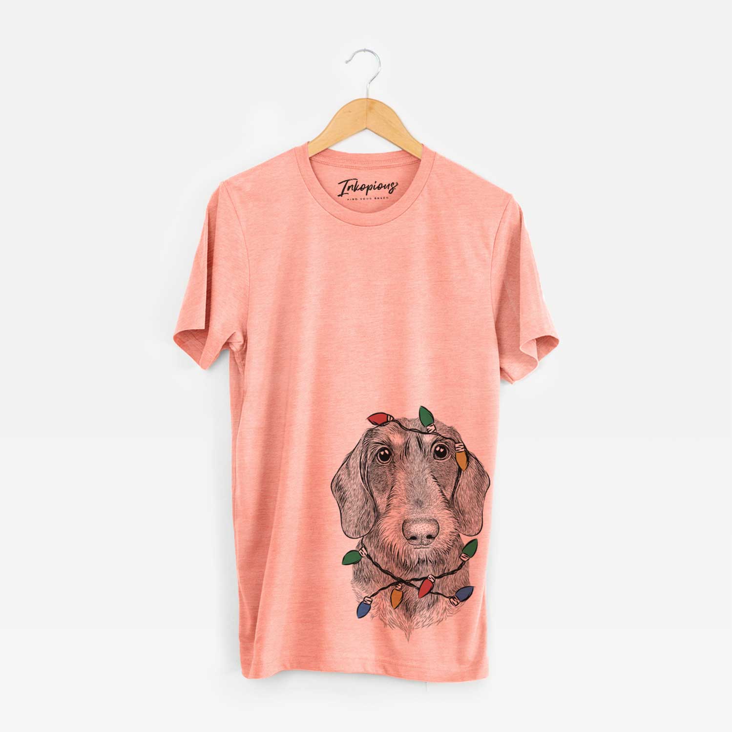 Hand-drawn sketch of Truman the Wirehaired Dachshund wrapped in Christmas lights on a Sunset Unisex crewneck