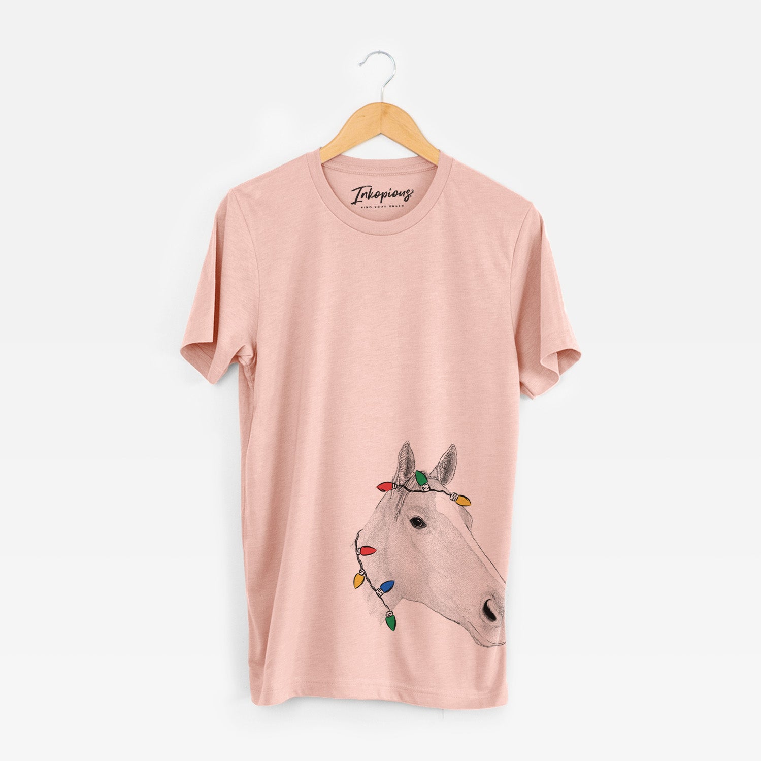 Hand-drawn sketch of Westley the Horse wrapped in Christmas lights on a Peach Unisex crewneck