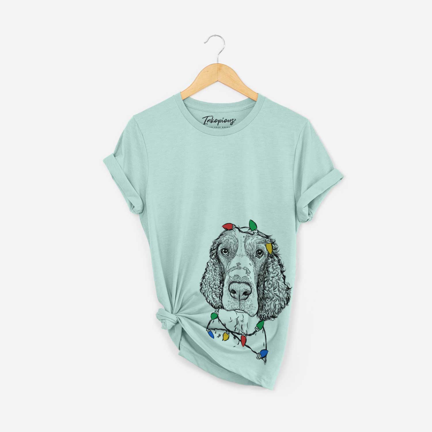 Hand-drawn sketch of Wilbur the English Springer Spaniel wrapped in Christmas lights on a Heather Sage Unisex crewneck