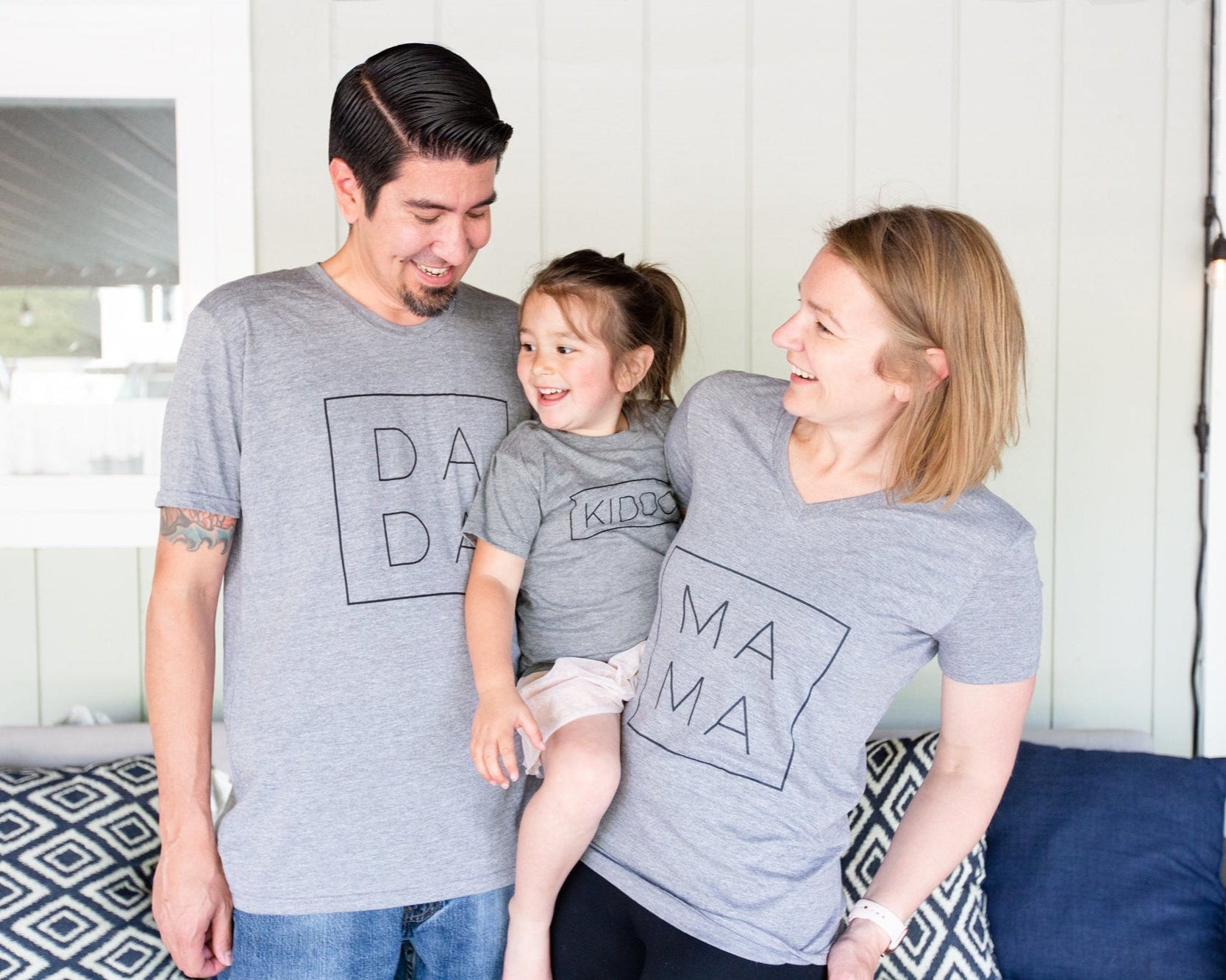 our happy family wearing shirts with Dada, Mama, and Kiddo printed in a modern font and square on grey matching shirts